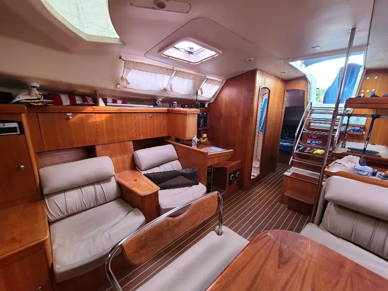 Slide: The Image of Interior of a 2004 Hunter 466 yacht, featuring wood paneling and comfortable seating. - 36