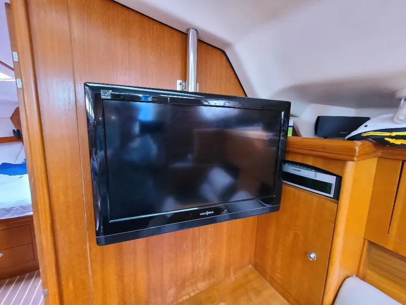 Slide: The Image of Flat-screen TV mounted in a 2004 Hunter 466 yacht interior with wooden cabinetry. - 37