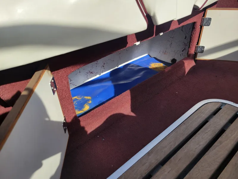 Slide: The Image of Open storage compartment in a 1991 Maxum 2100 XC boat with red carpet interior. - 19