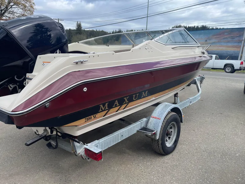 Slide: The Image of 1991 Maxum 2100 XC boat on a trailer, maroon and white color scheme. - 2