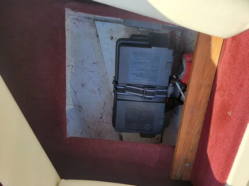 Slide: The Image of Battery compartment of a 1991 Maxum 2100 XC boat with red carpet and wooden trim. - 21
