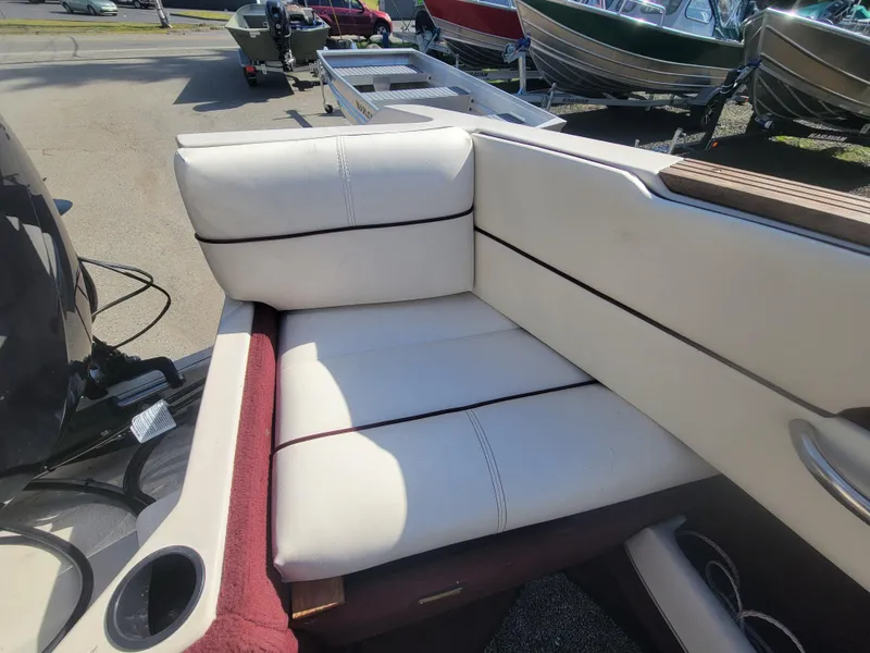 Slide: The Image of White leather seating on a 1991 Maxum 2100 XC boat, with cup holder and motor visible. - 8