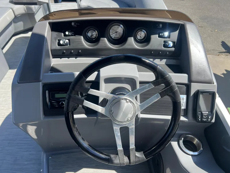 Slide: The Image of 2022 Bennington 23 L boat dashboard with steering wheel and gauges. - 10
