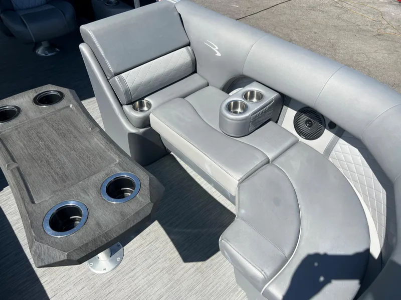 Slide: The Image of 2022 Bennington 23 L boat interior with gray seating and cup holders. - 20