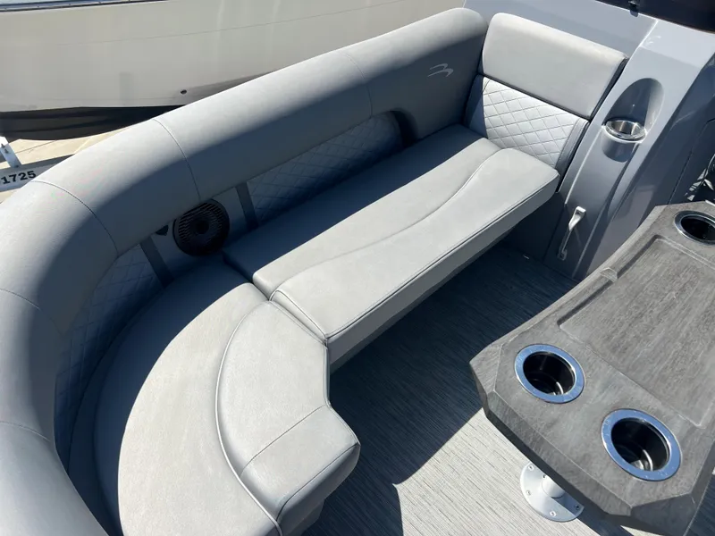 Slide: The Image of 2022 Bennington 23 L boat interior with gray seating and cup holders. - 21