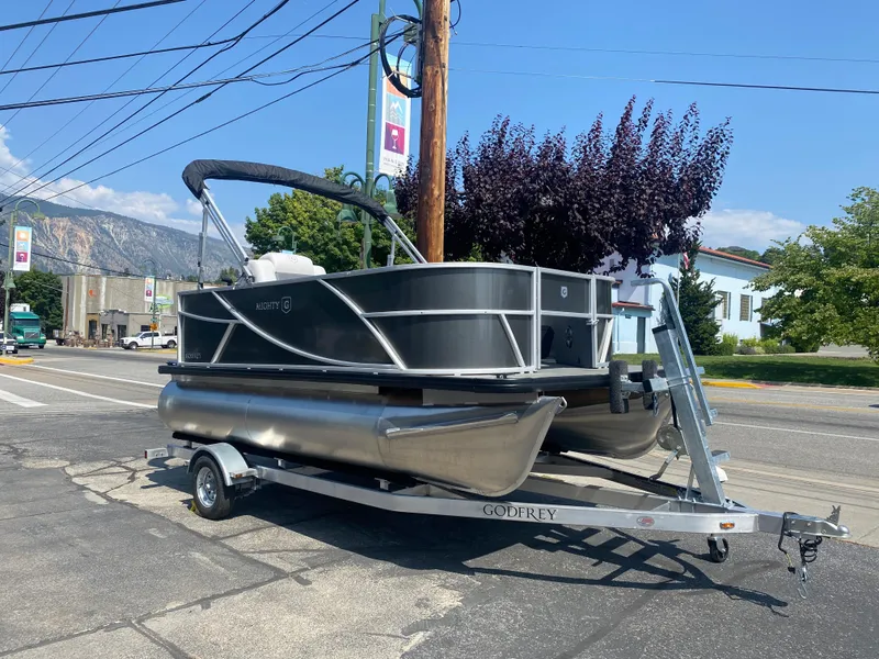 The Image of 2023 Godfrey MIGHTY G 1476F pontoon boat on trailer in urban setting. - 1