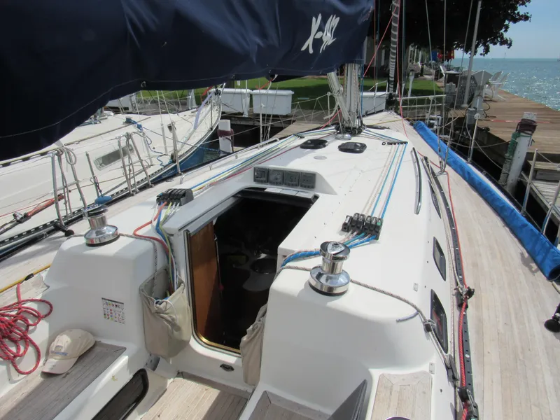 Slide: The Image of 2000 X-Yachts X-412 sailboat deck with open cabin, docked by the water. - 29