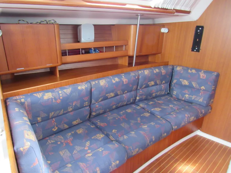 Slide: The Image of Interior of 2000 X-Yachts X-412 with blue patterned sofa and wooden paneling. - 5
