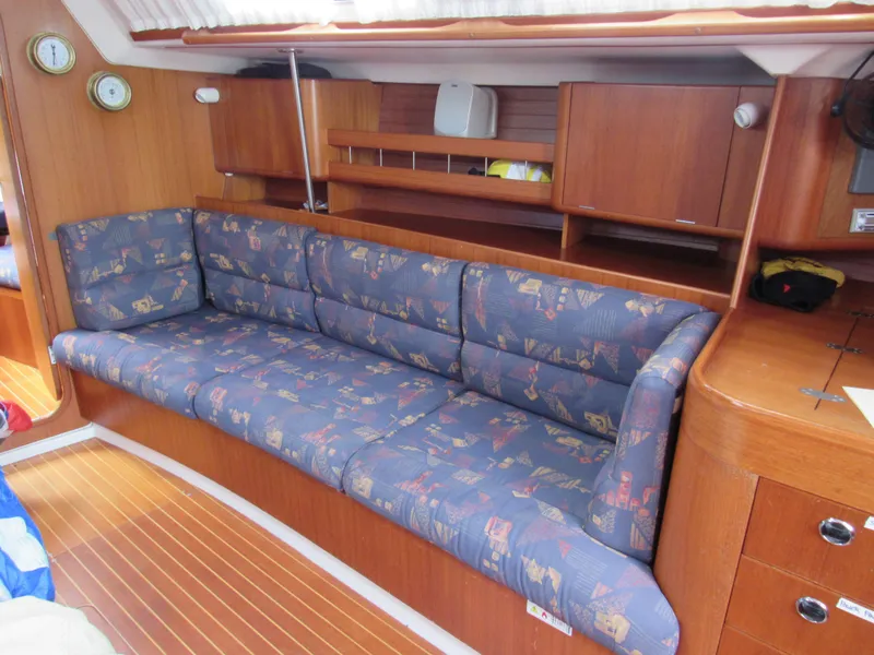 Slide: The Image of Interior of 2000 X-Yachts X-412 sailboat with blue cushioned seating and wooden cabinetry. - 6