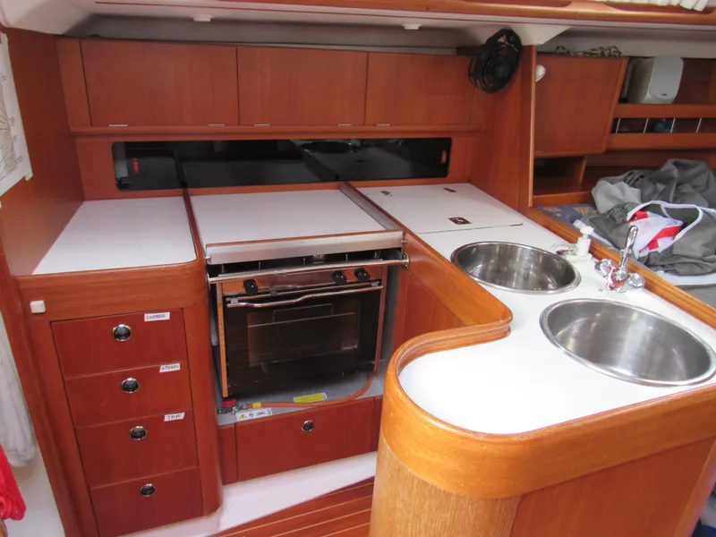Slide: The Image of Interior of 2000 X-Yachts X-412 sailboat kitchen with wood cabinetry and dual sinks. - 8