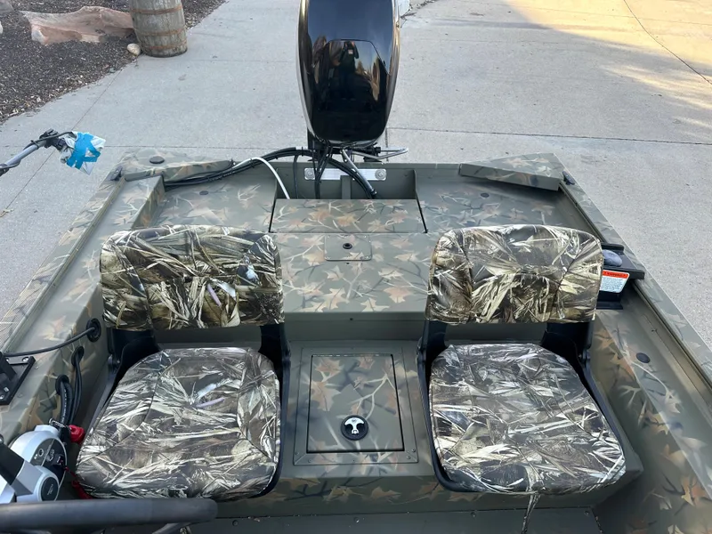 Slide: The Image of 2023 Tracker Grizzly 1754 SC boat with camo seats and outboard motor. - 7