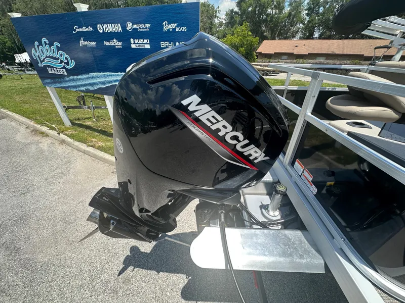 Slide: The Image of 2024 Ranger Reata 200F with Mercury outboard motor at a marina. - 13