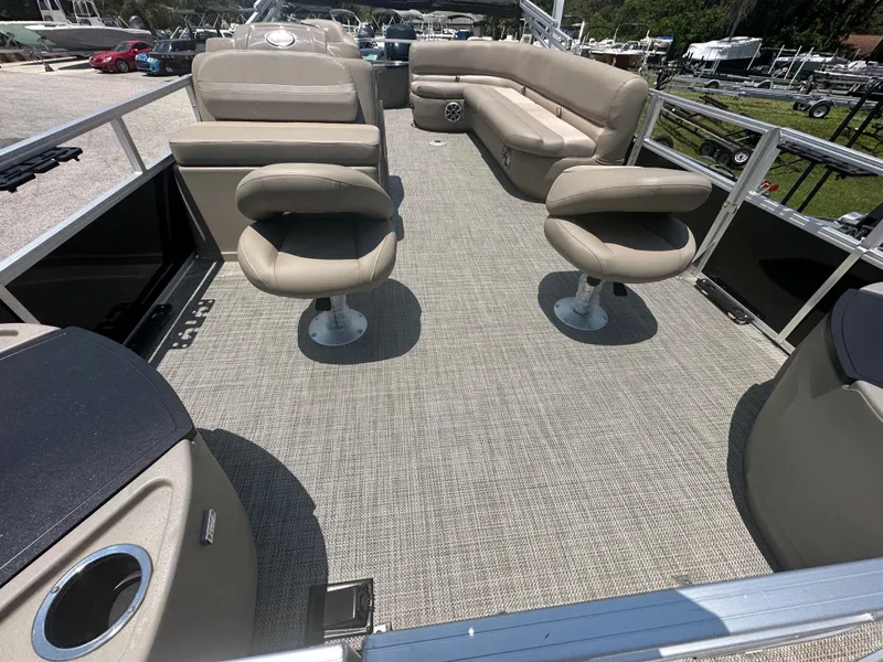 Slide: The Image of 2024 Ranger Reata 200F pontoon boat interior with beige seating and carpeted floor. - 7