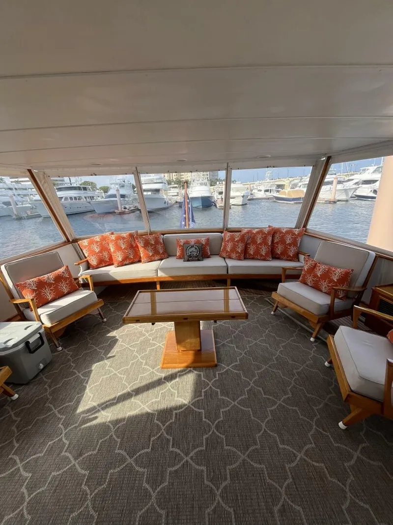 Slide: The Image of Spacious interior of a 1972 Trumpy 72 Houseboat with comfortable seating and marina view. - 14