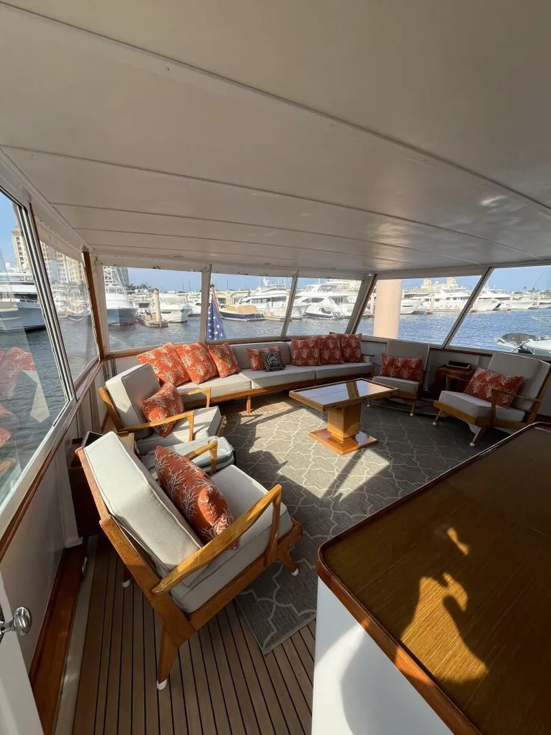 Slide: The Image of 1972 Trumpy 72 Houseboat interior with elegant seating and marina view. - 15