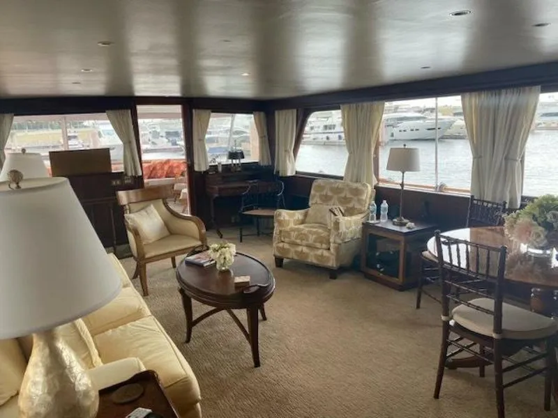 Slide: The Image of Interior of a 1972 Trumpy 72 Houseboat with elegant furnishings and large windows. - 16