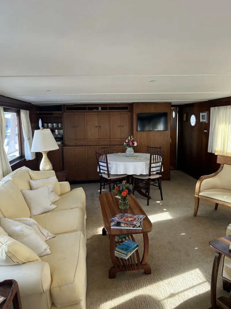 Slide: The Image of Interior of a 1972 Trumpy 72 Houseboat with cozy seating and dining area. - 17