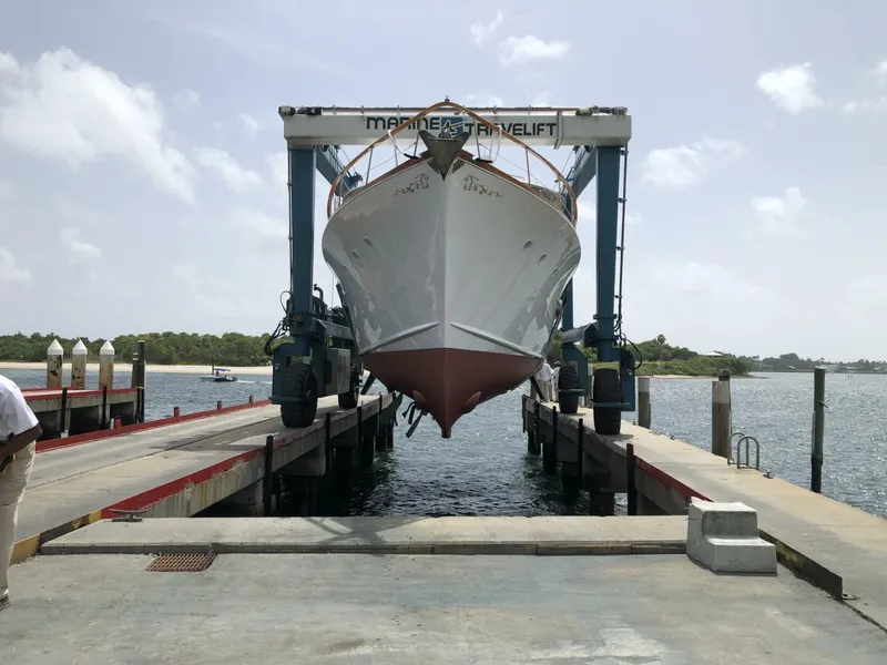 Slide: The Image of 1972 Trumpy 72 Houseboat on a marine travel lift at a dock. - 2