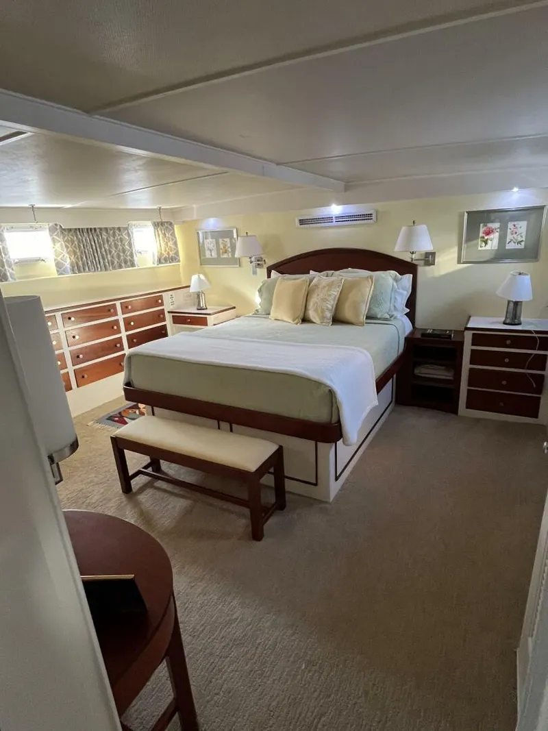 Slide: The Image of Luxurious bedroom interior of a 1972 Trumpy 72 Houseboat with a cozy bed and ample storage. - 24