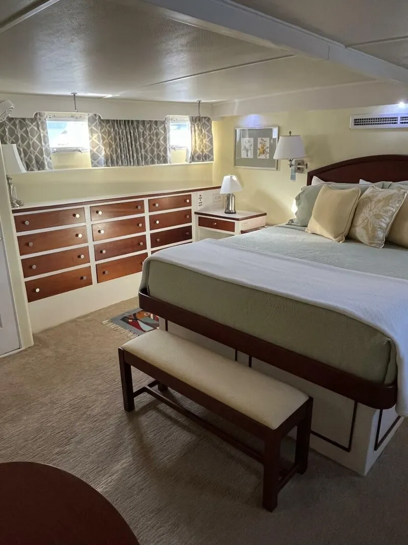 Slide: The Image of Interior of 1972 Trumpy 72 Houseboat bedroom with bed, dresser, and bench. - 25