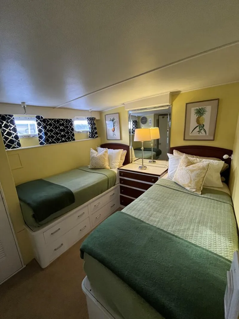 Slide: The Image of Cozy bedroom in a 1972 Trumpy 72 Houseboat with twin beds and nautical decor. - 27