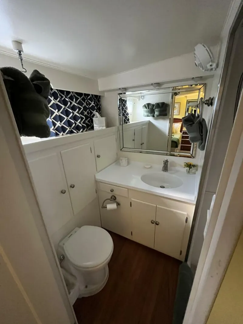 Slide: The Image of 1972 Trumpy 72 Houseboat bathroom with white cabinets, sink, and toilet. - 29