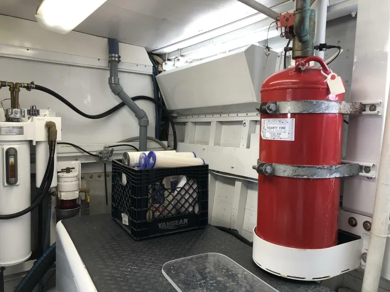 Slide: The Image of Engine room of a 1972 Trumpy 72 Houseboat with fire extinguisher and maintenance equipment. - 34
