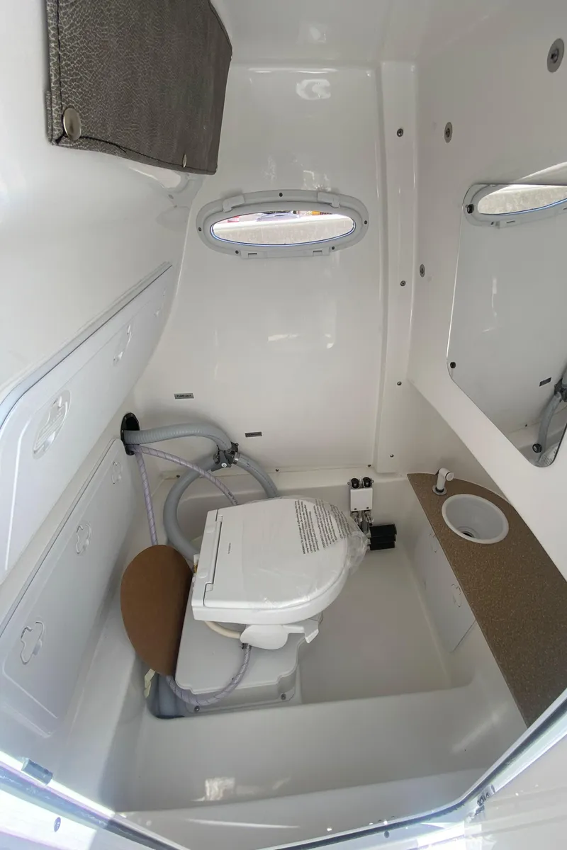 Slide: The Image of 2023 Sea Pro 259 boat interior with marine toilet and portholes. - 20