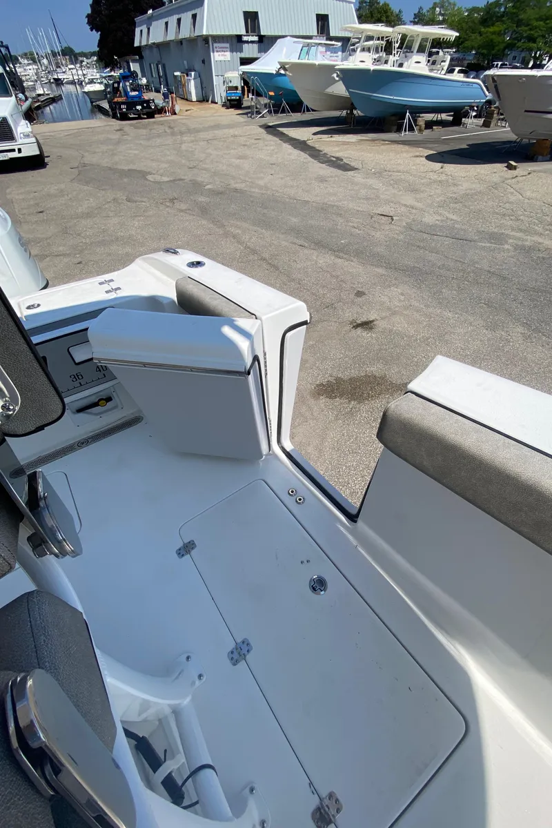 Slide: The Image of 2023 Sea Pro 259 boat interior at a marina with other boats in the background. - 9
