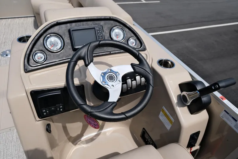 Slide: The Image of 2023 SunCatcher Fusion 322RC boat dashboard with steering wheel and controls. - 11