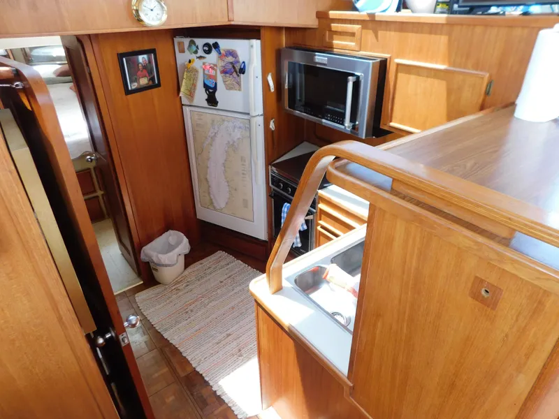Slide: The Image of 1988 Chris-Craft 426 Catalina yacht interior with kitchen, wooden cabinetry, and appliances. - 18