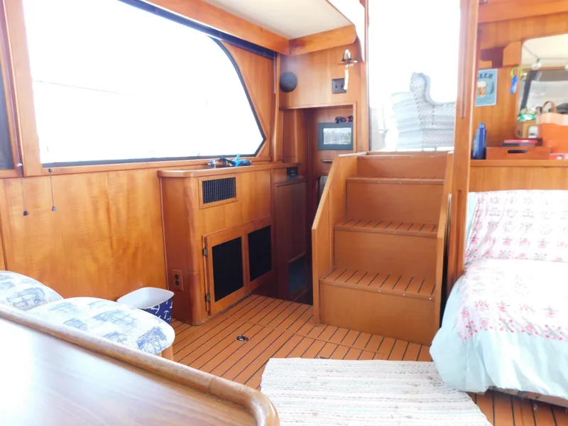 Slide: The Image of 1988 Chris-Craft 426 Catalina interior with wooden finish and cozy seating area. - 20