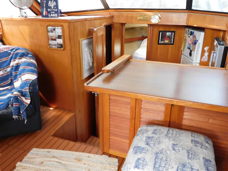 Slide: The Image of 1988 Chris-Craft 426 Catalina interior with wood paneling, cozy seating, and nautical decor. - 45