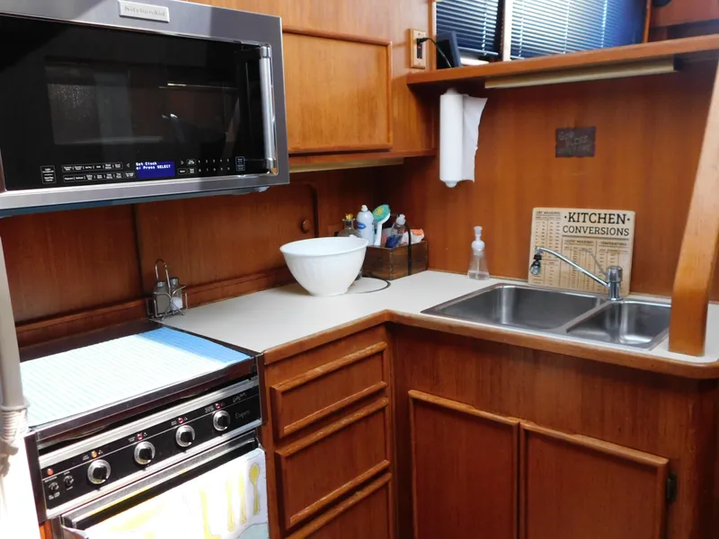 Slide: The Image of 1988 Chris-Craft 426 Catalina kitchen with microwave, stove, and double sink. - 49