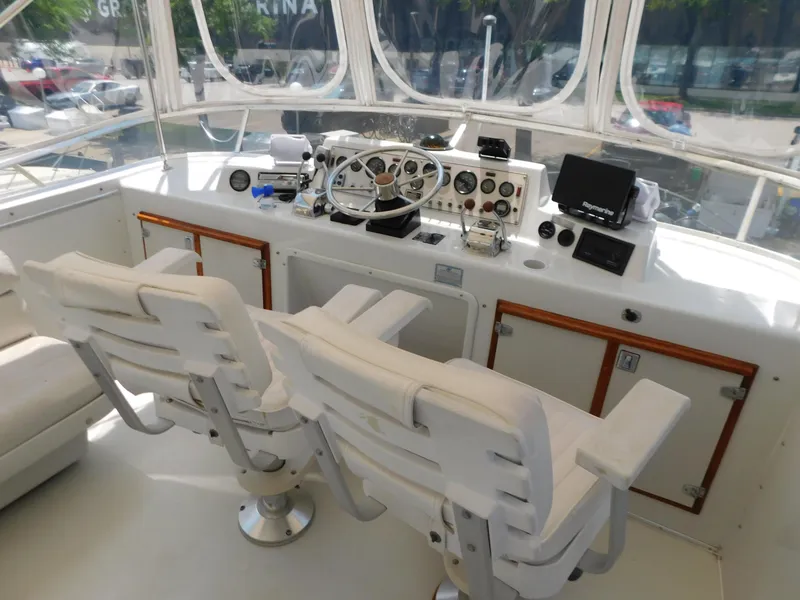 Slide: The Image of 1988 Chris-Craft 426 Catalina helm with dual white captain chairs and navigation instruments. - 8