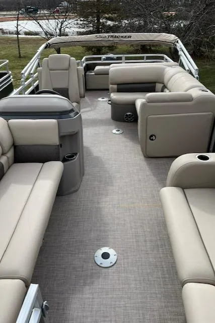 Slide: The Image of 2024 Sun Tracker SportFish 22 DLX pontoon boat interior with beige seating. - 6