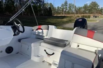 Slide: The Image of 2024 Tahoe T18 boat interior with seating and steering wheel, parked outdoors. - 3