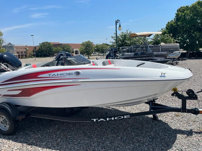 Slide: The Image of 2024 Tahoe T16 boat with red accents on a trailer in a parking lot. - 2