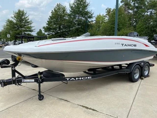 Slide: The Image of 2024 Tahoe 2150 boat on a trailer, parked outdoors. - 0