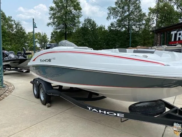 Slide: The Image of 2024 Tahoe 2150 boat on trailer, parked outdoors. - 1