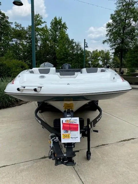 Slide: The Image of 2024 Tahoe 2150 boat on a trailer, displayed outdoors. - 2