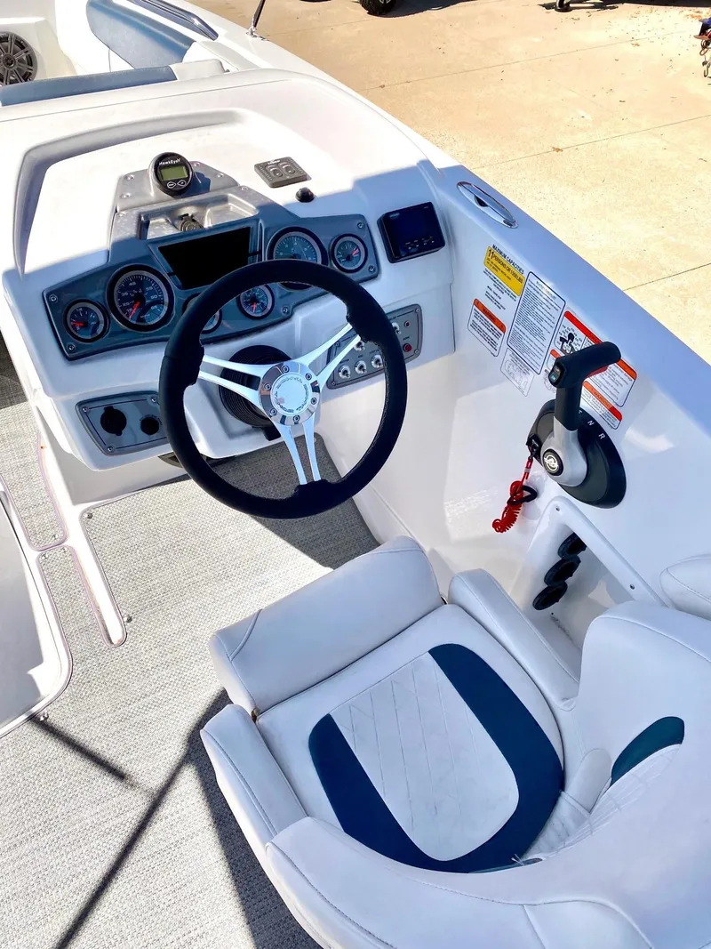 Slide: The Image of 2024 Tahoe 2150 boat cockpit with steering wheel and control panel. - 2