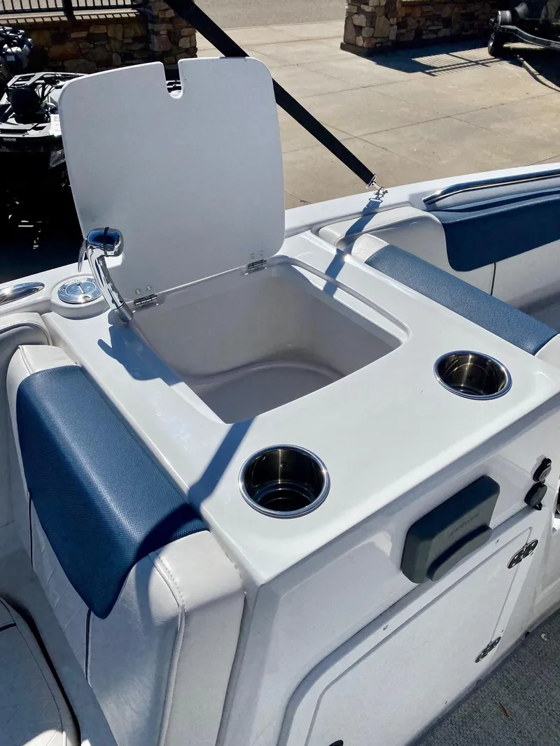 Slide: The Image of 2024 Tahoe 2150 boat with open storage compartment and cup holders. - 5