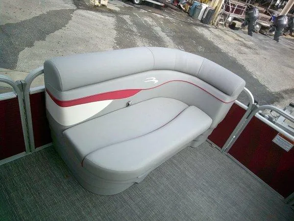 Slide: The Image of 2024 Bennington 188SVL pontoon boat seating with gray and red upholstery. - 6