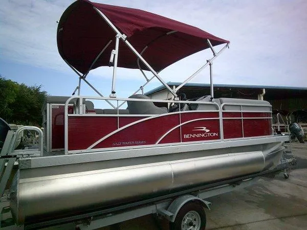 Slide: The Image of 2024 Bennington 188SVL pontoon boat with red canopy on trailer. - 8