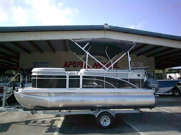 Slide: The Image of 2024 Bennington 188SVL pontoon boat on a trailer at a marina. - 9