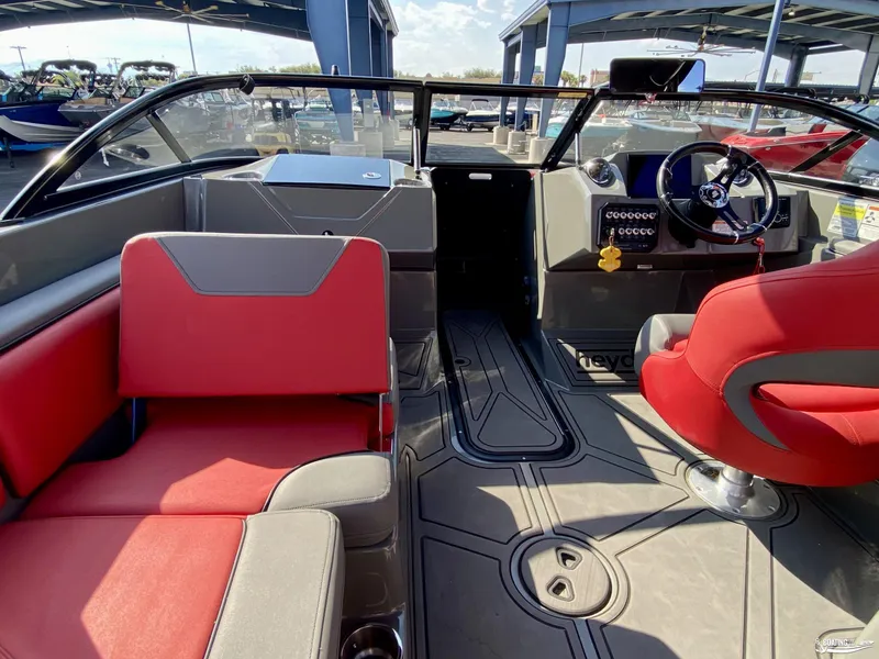 Slide: The Image of 2022 Heyday WTSurf boat interior with red and gray seating, steering wheel, and dashboard. - 10