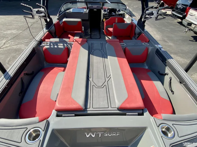 Slide: The Image of 2022 Heyday WTSurf boat interior with red and gray seating, cup holders, and wakeboard racks. - 11