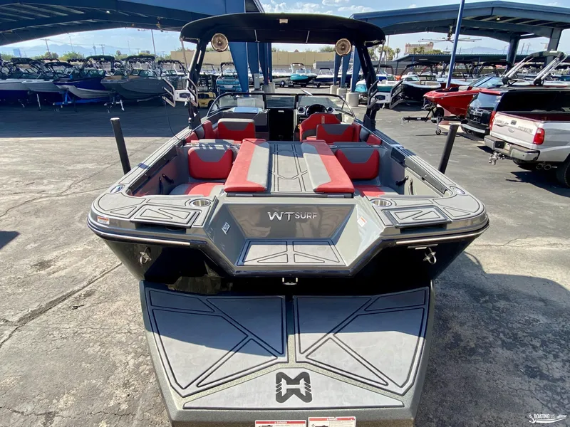 Slide: The Image of 2022 Heyday WTSurf boat with red and gray interior, parked in a marina. - 4