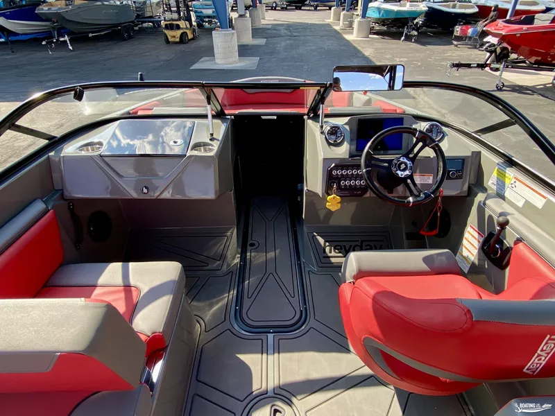 Slide: The Image of 2022 Heyday WTSurf boat interior with red and gray seating, steering wheel, and control panel. - 5